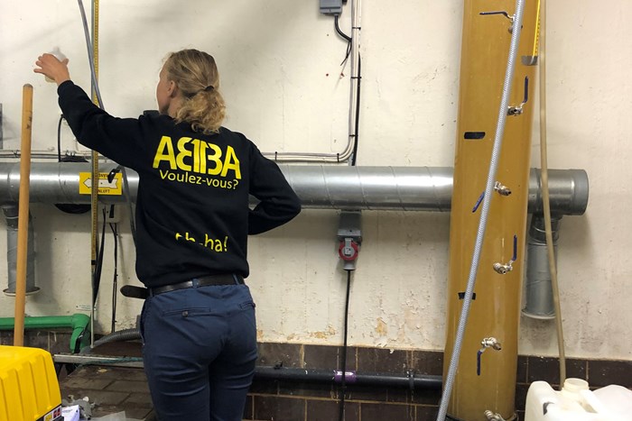 Kvinna arbetar med vattenprover i reningsanläggning. Foto.